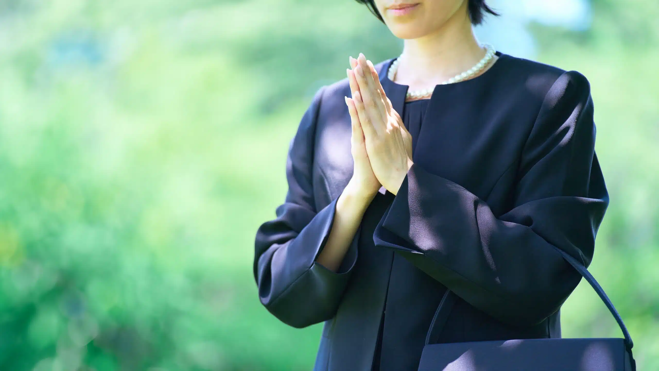 Woman praying at a funeral wearing cotton funeral attire