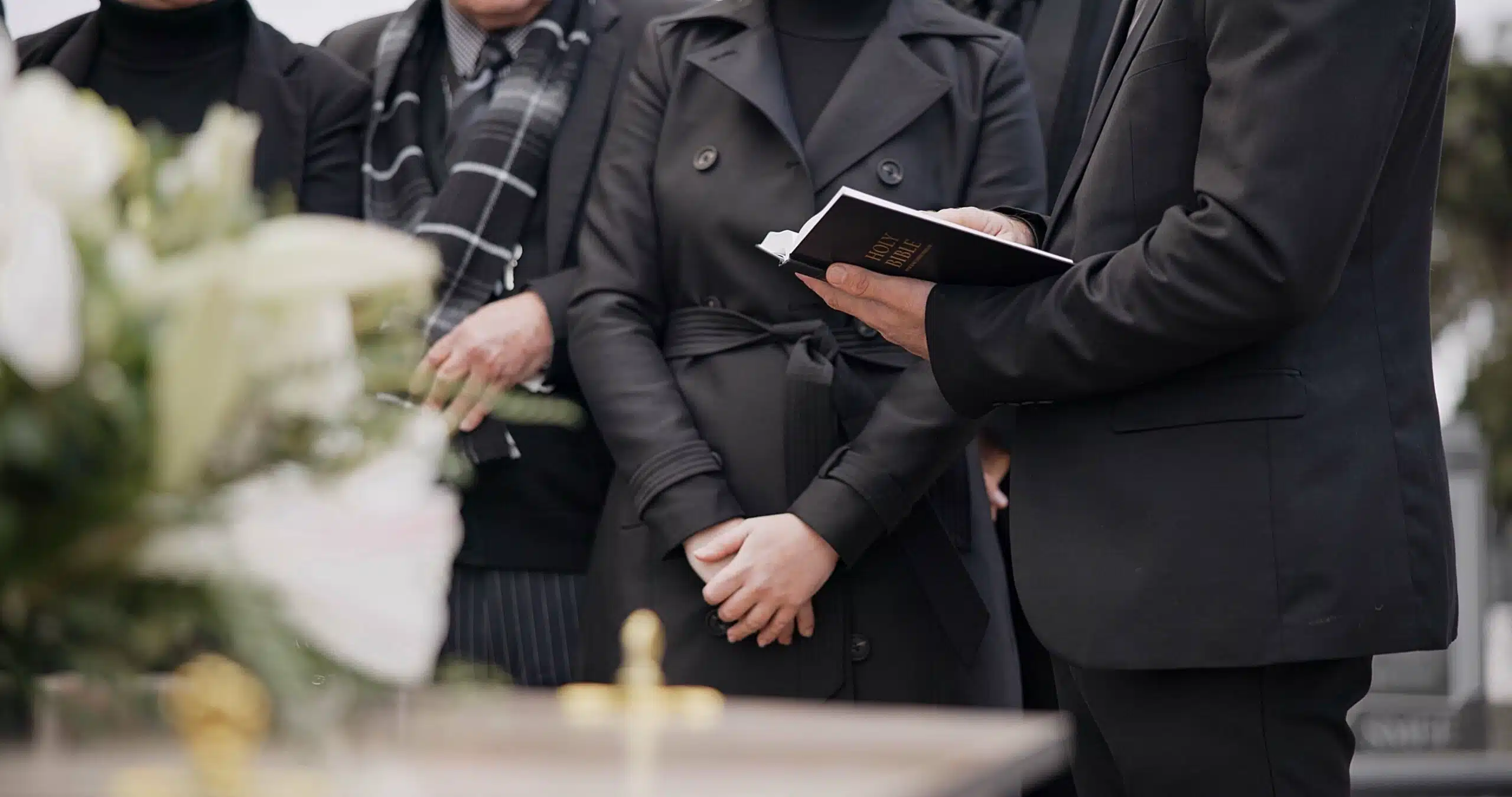 Group of people mourning at an outdoor funeral